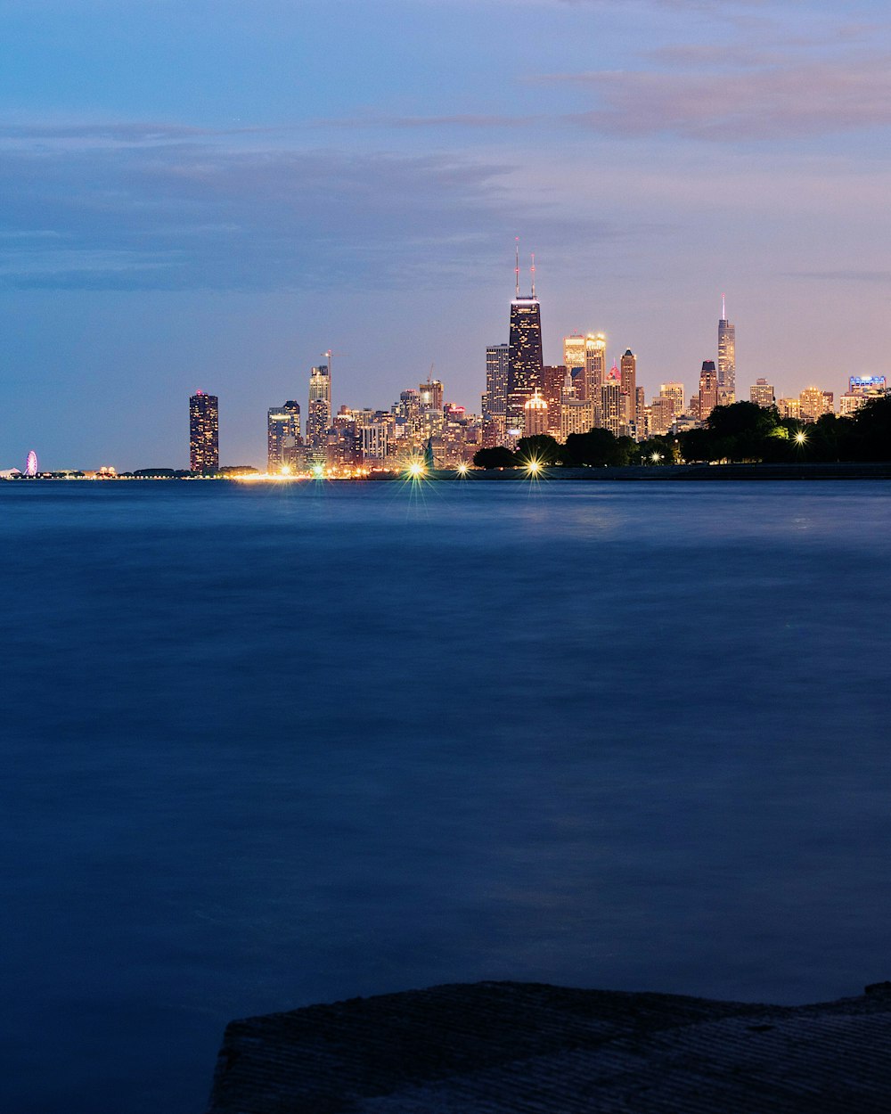 Foto de paisaje de edificios iluminados cerca del cuerpo de agua