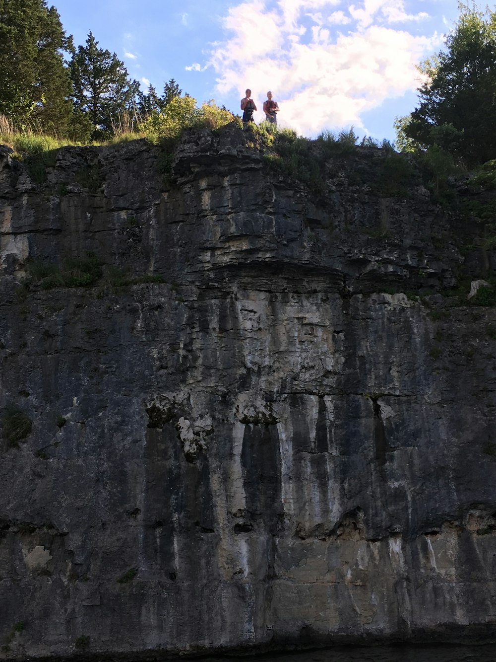 昼間、空を見下ろす崖のそばに立つ二人の男