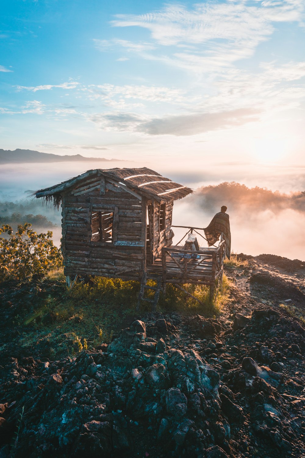 person in wooden cabin on hill