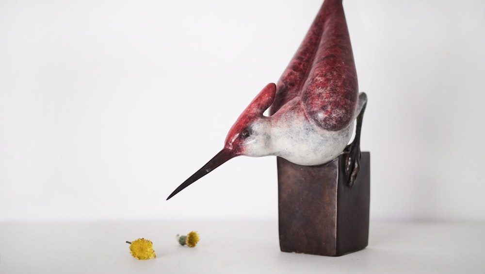 brown and white wooden bird on top of block figurine