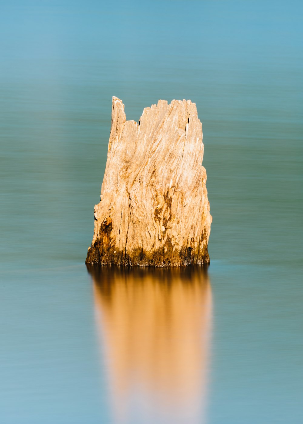 formazione rocciosa marrone sullo specchio d'acqua