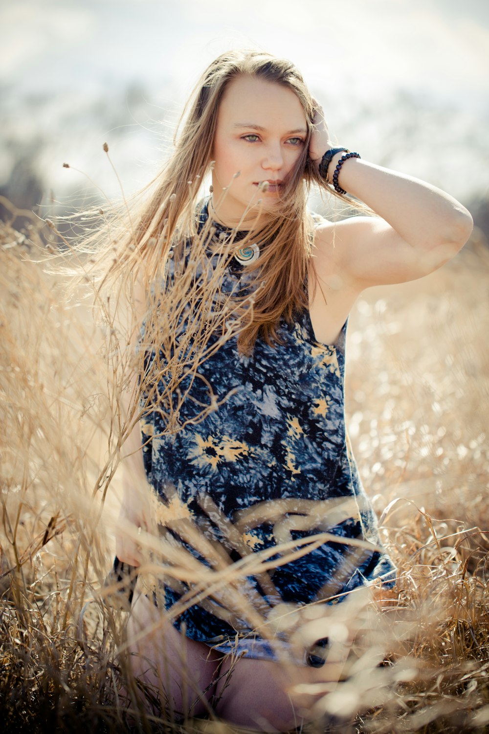 close up photography of woman standing between brown grasses during daytime