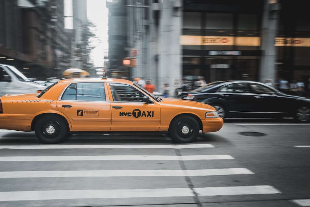 orange New York City taxi on pedestrian lane at daytime