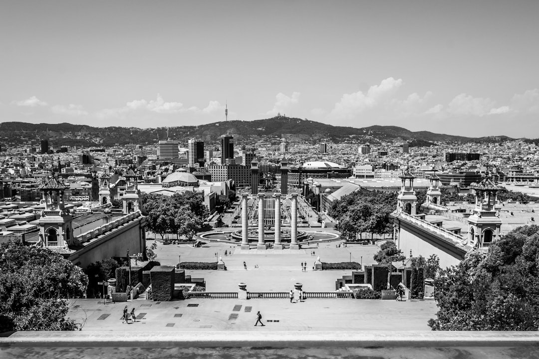 grayscale photography of city with high-rise buildings viewing people walking