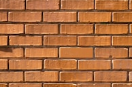 Wide shot of a freshly built brick wall with clean lines.