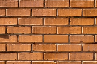 Wide shot of a brick wall being built under clear daylight.