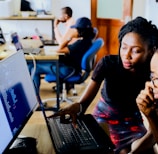 woman and man sitting in front of monitor