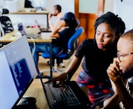 woman and man sitting in front of monitor