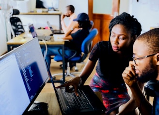 woman and man sitting in front of monitor