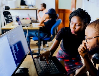 woman and man sitting in front of monitor