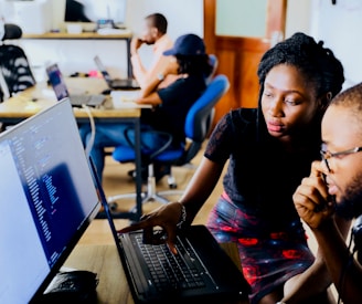 woman and man sitting in front of monitor