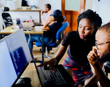 woman and man sitting in front of monitor