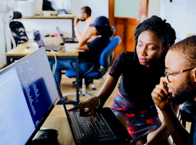 woman and man sitting in front of monitor