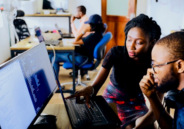 woman and man sitting in front of monitor