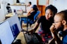 woman and man sitting in front of monitor