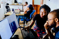 woman and man sitting in front of monitor