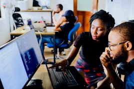 woman and man sitting in front of monitor