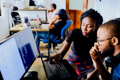 woman and man sitting in front of monitor