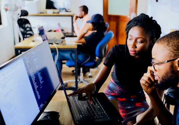 woman and man sitting in front of monitor