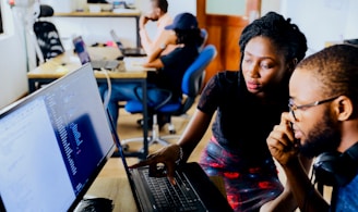 woman and man sitting in front of monitor