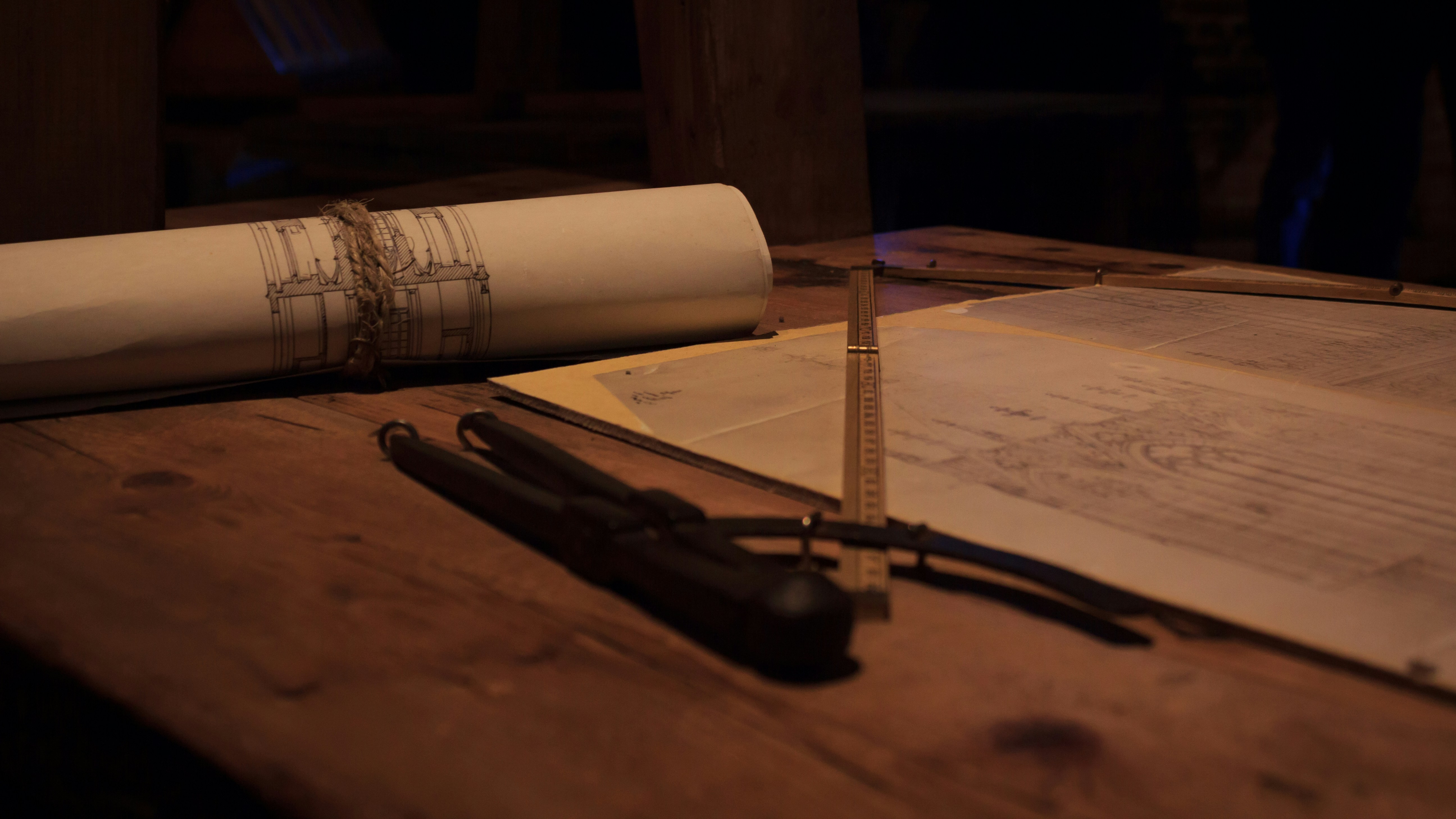 Architectural blueprints and construction plans spread on table with hard hat, pencils and tools, professional setting