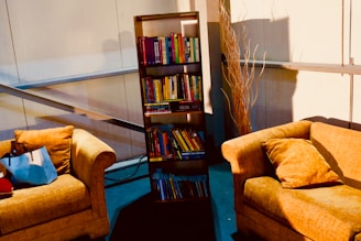 A sunlit living room with a soft beige bean bag sofa next to a stack of favorite books