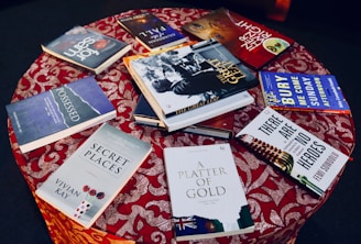 A rustic wooden table displaying newly published books with whimsical covers.