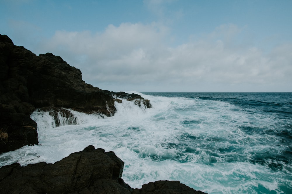 ondas derrubando rochas costeiras durante o dia