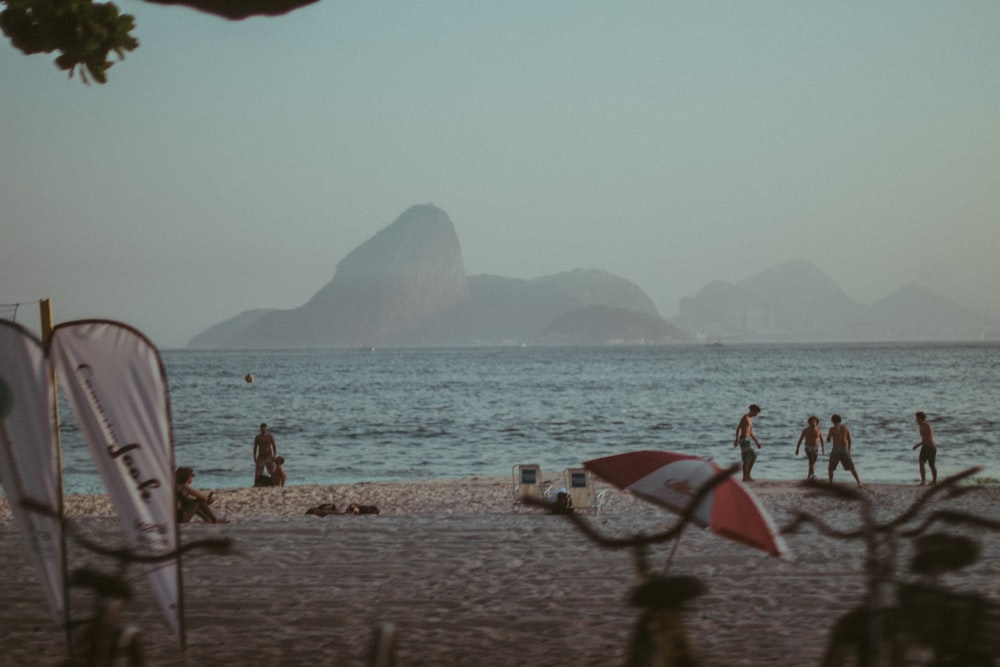 people standing beside sea under gray sky