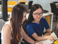 two women sitting beside table