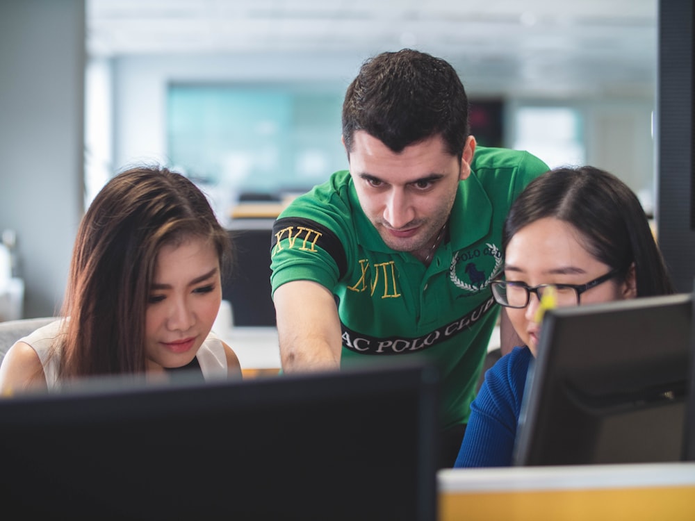 Dos mujeres y un hombre en la pantalla de la computadora