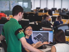 A creative workspace showing designers collaborating on website and graphic projects.