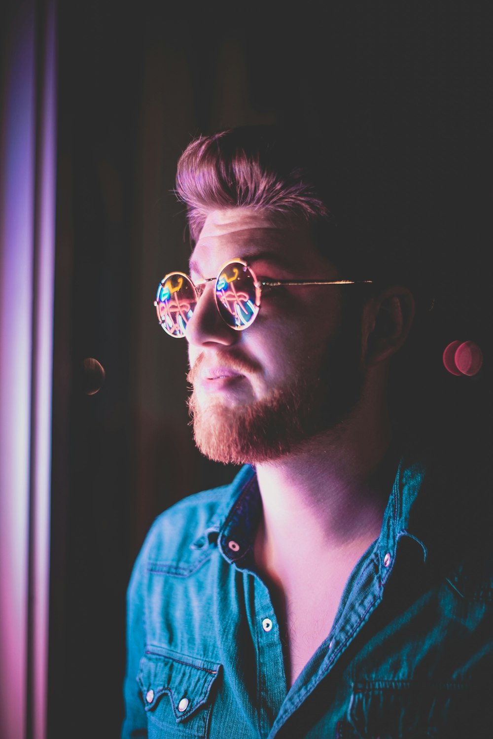 homme portant des lunettes de soleil dans une pièce faiblement éclairée