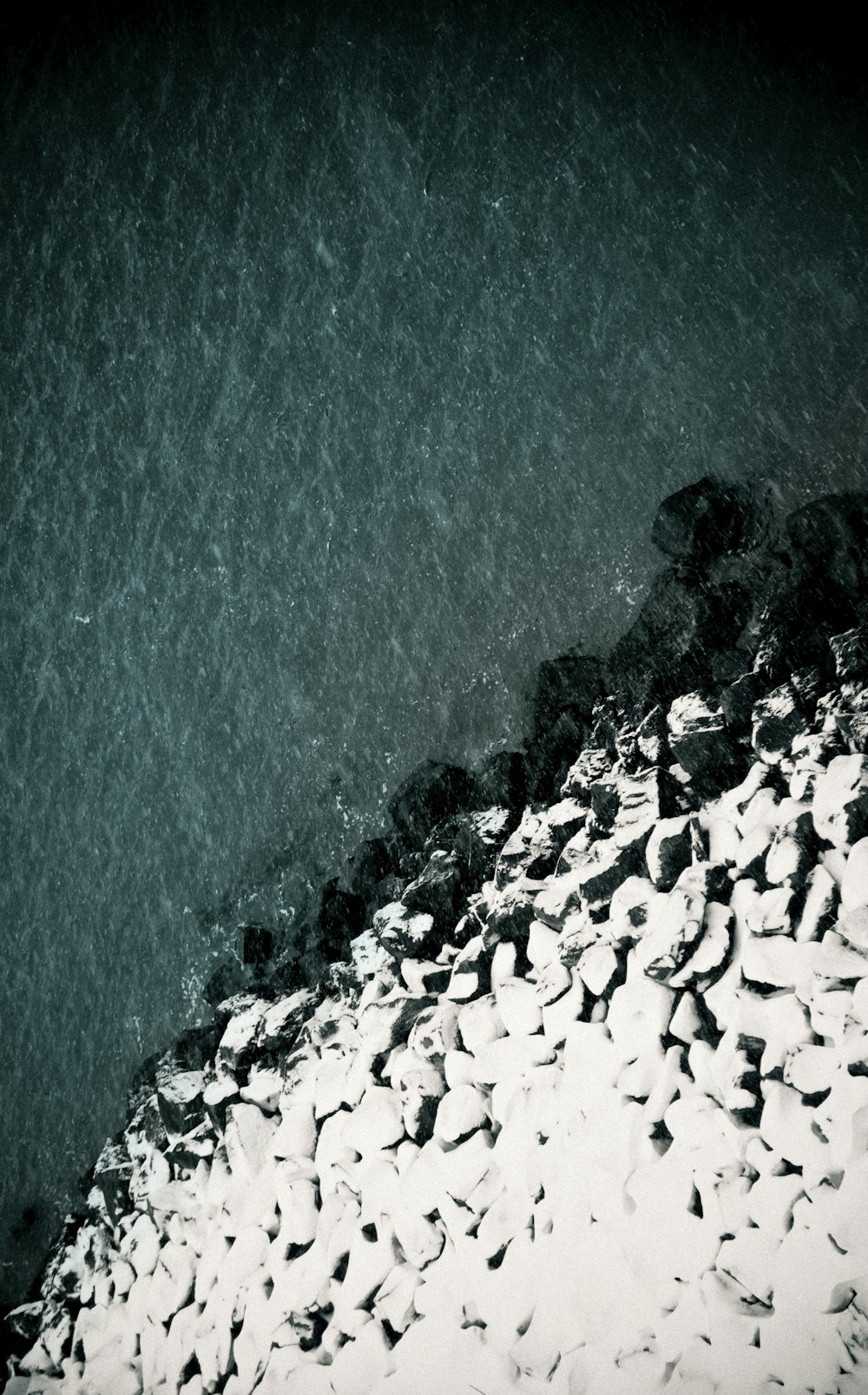 uma foto em preto e branco de água e rochas