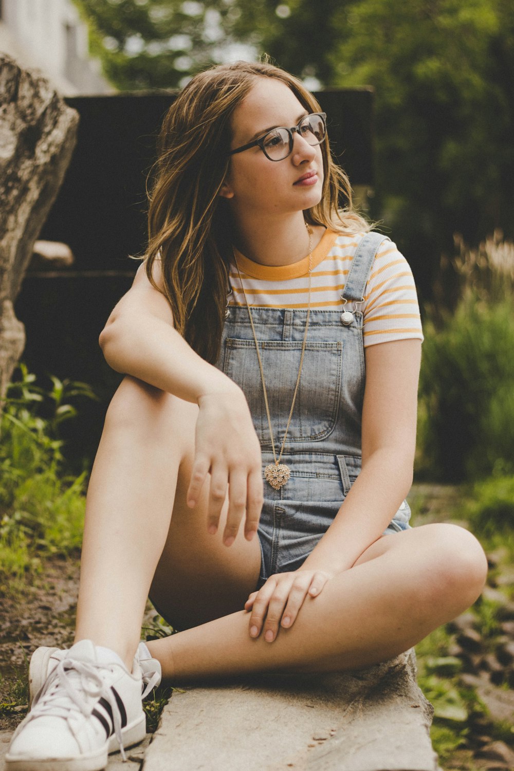 woman sitting on concrete pavement