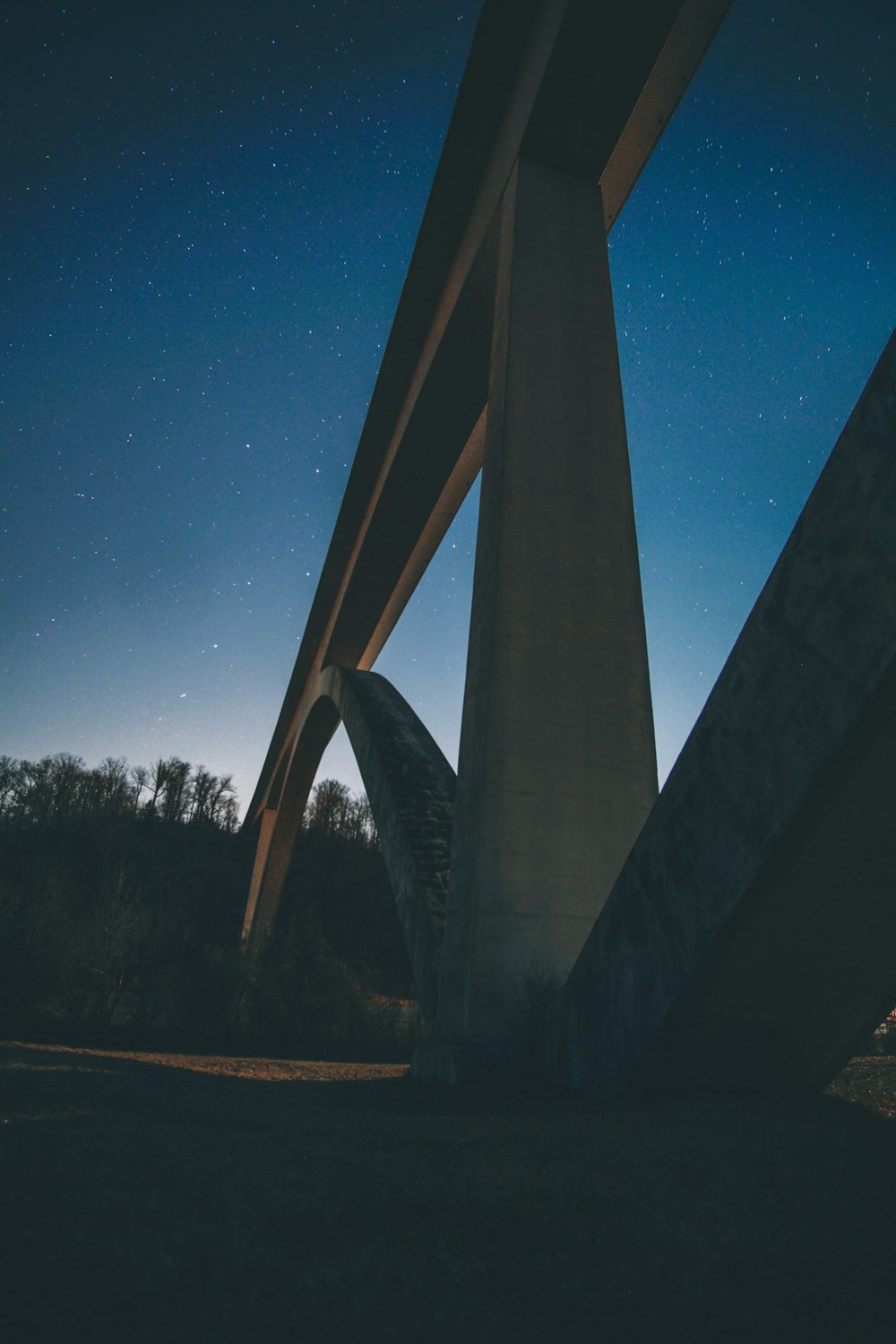 Fotografía de primer plano de un puente colgante de hormigón durante la noche