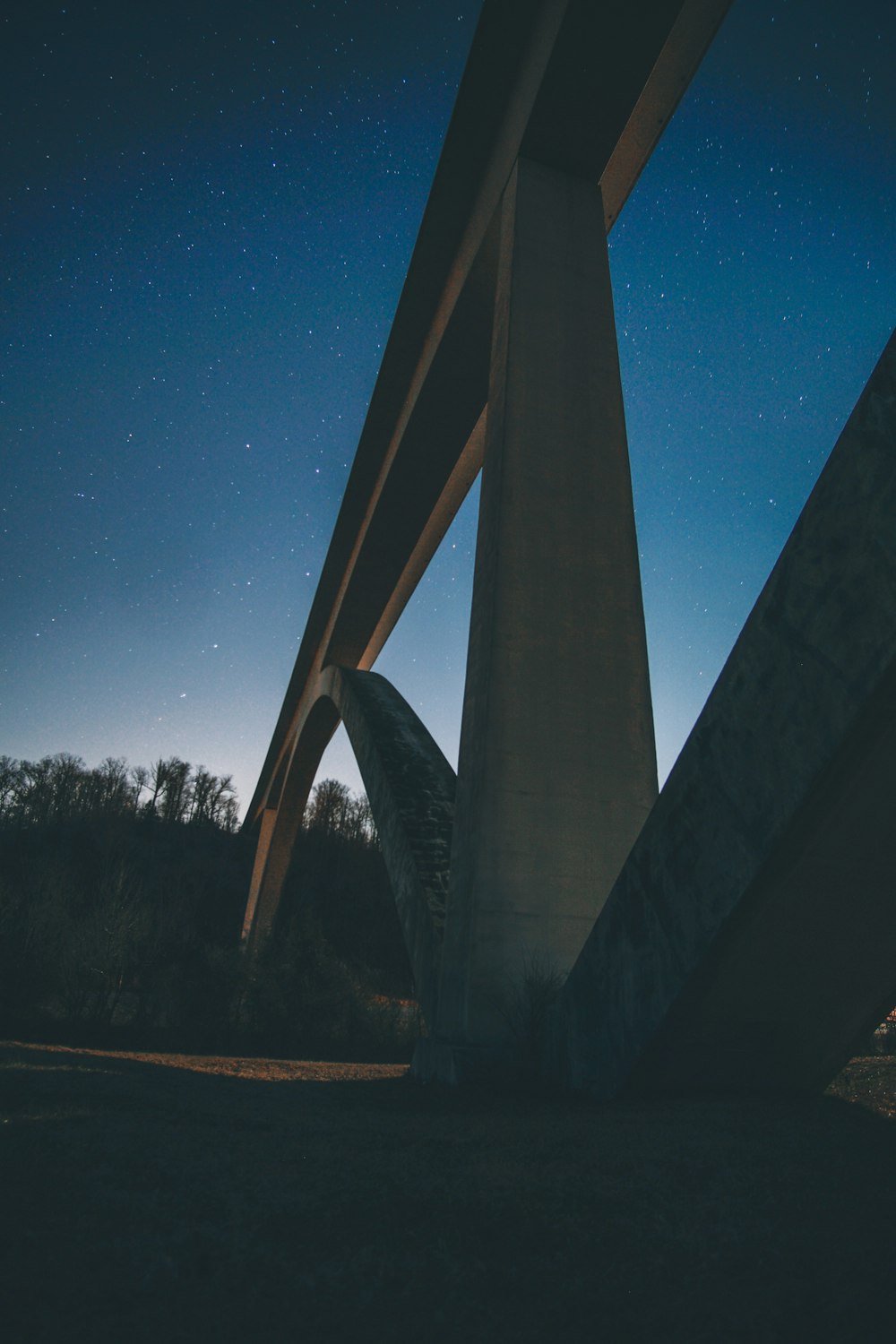 fotografia ravvicinata del ponte sospeso in calcestruzzo durante la notte