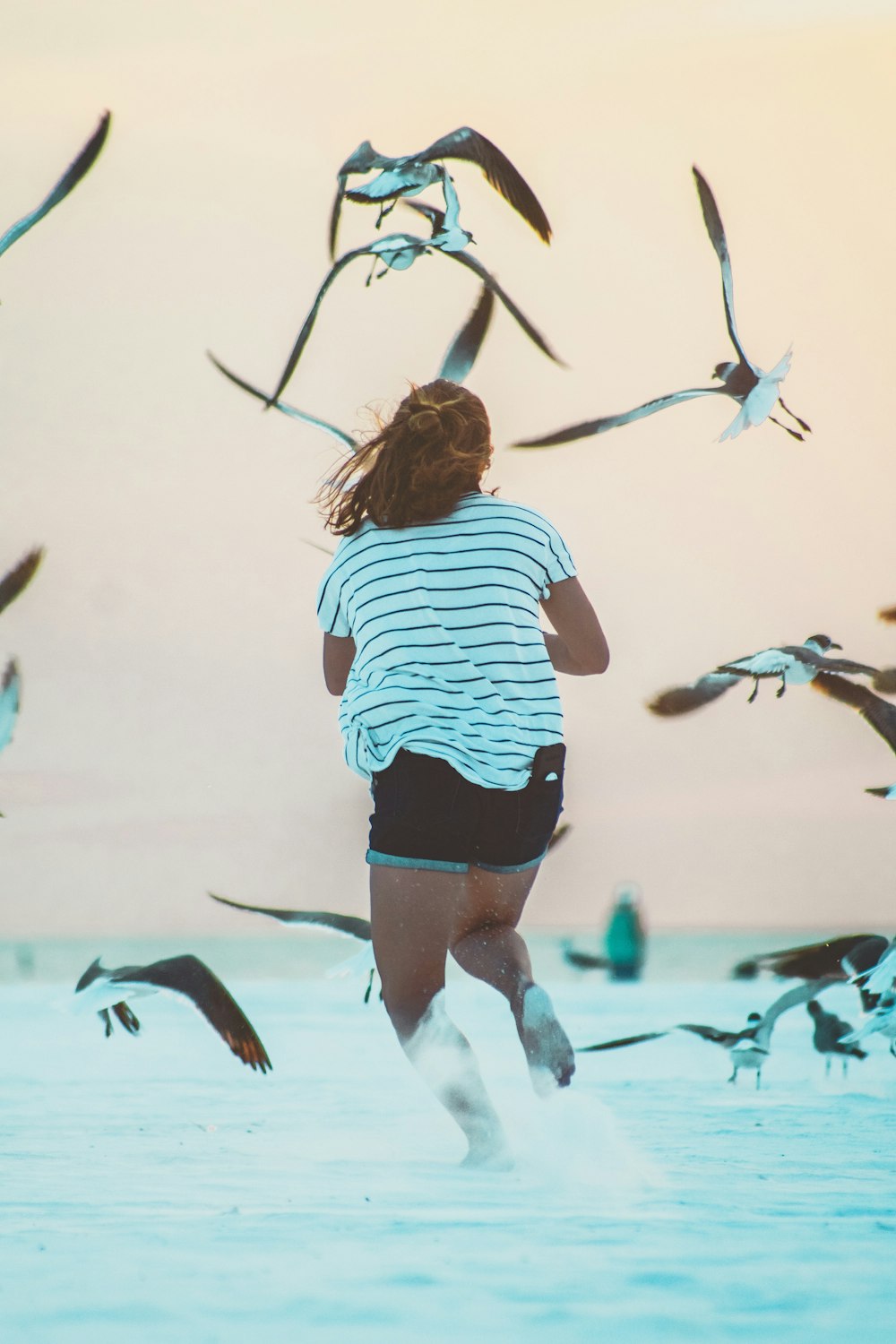 running woman surrounded by birds at daytime