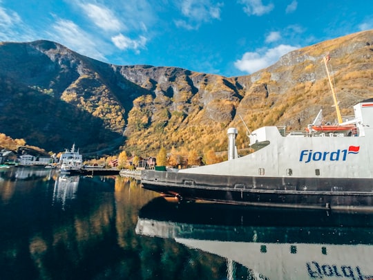 Ffjord1 ship on body of water near ships and mountains in Flam Norway