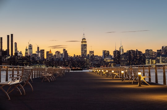 white metal bench near railings near body of water during golden hour in East River State Park United States