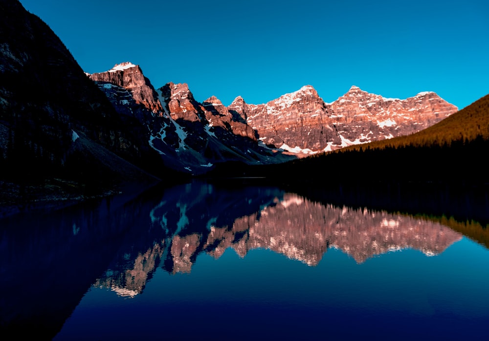 rocky mountain near the body of water photography