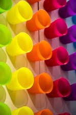 A colorful display of various cups arranged on wooden shelves, highlighting different styles and textures.