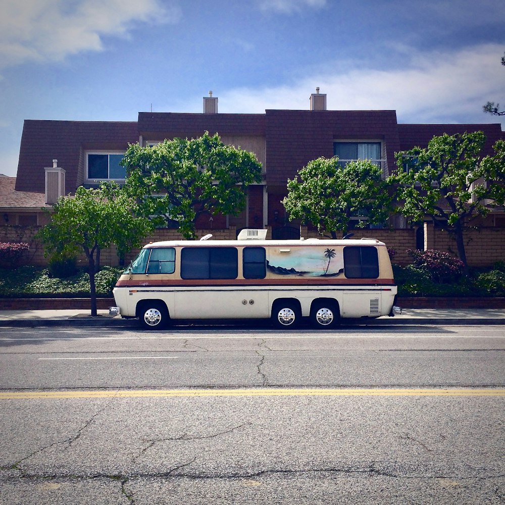 white van parked outside brown house