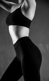 grayscale photo of person wearing sports bra and leggings