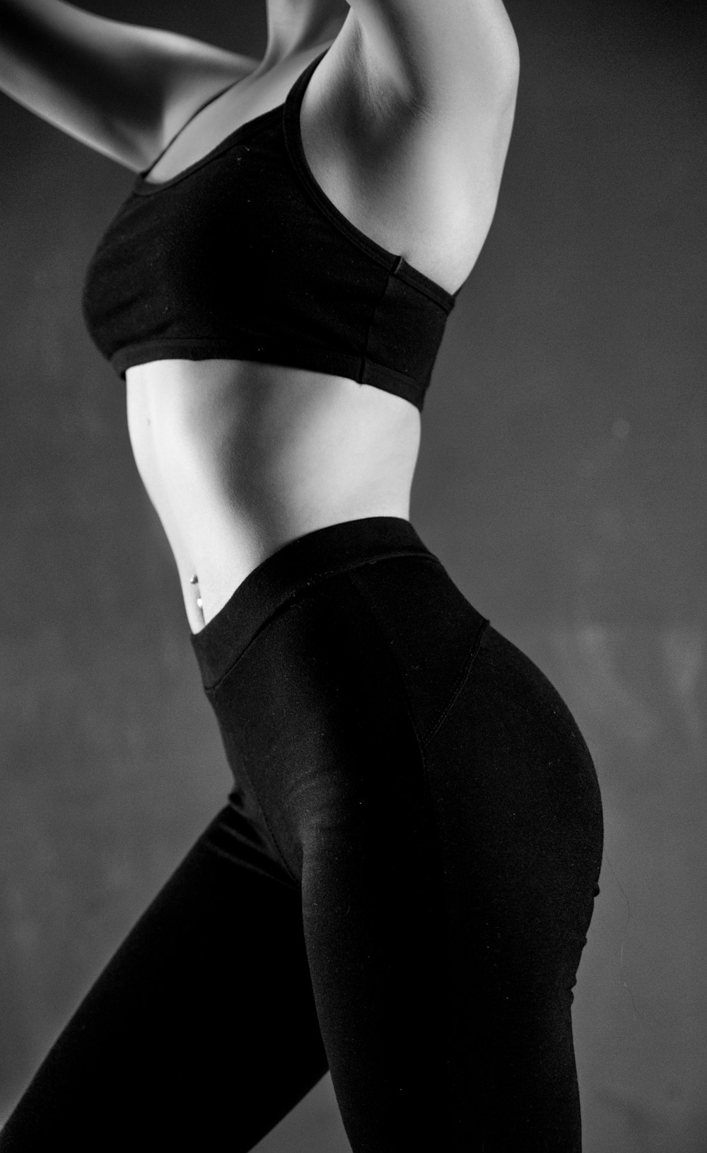 grayscale photo of person wearing sports bra and leggings
