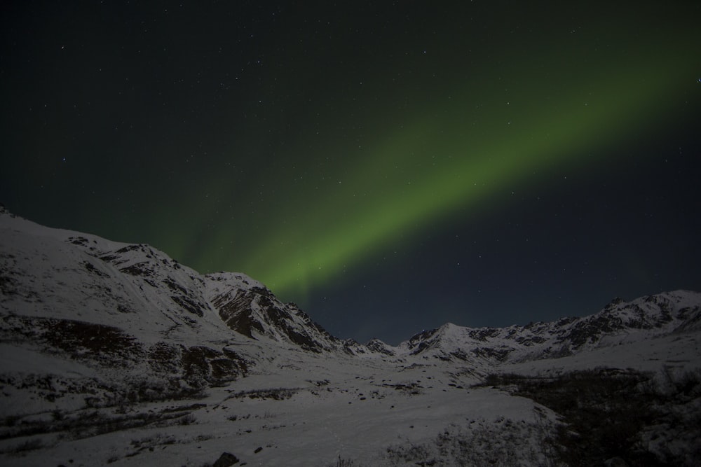 Montanha coberta de neve sob luzes de aurora