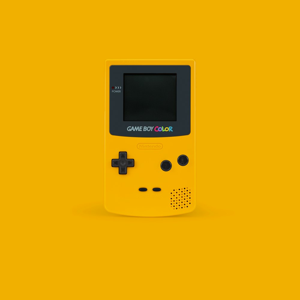branco e preto Nintendo Game Boy Color na superfície amarela