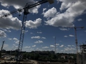 A scenic view of a construction site with workers and machinery under a clear blue sky.