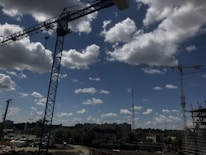 Construction site with workers and heavy machinery under clear sky.