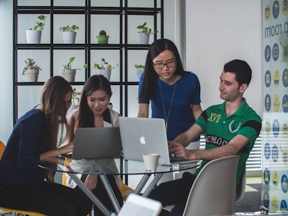 A dynamic group photo of the zesols team collaborating around a table filled with laptops, sketches, and coffee cups.